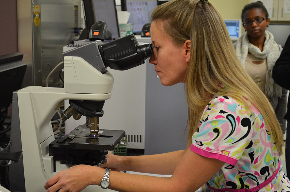 Lady using microscope in healthcare